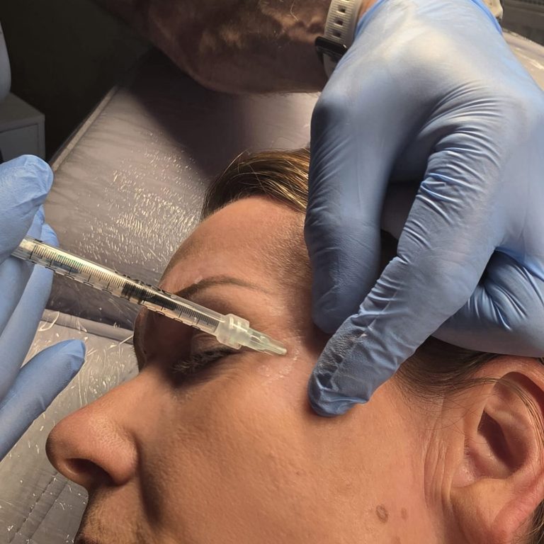 Een arts voert een injectiebehandeling uit bij een patiënt.